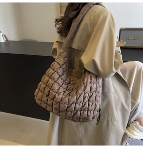 Detailed texture of brown quilted cloud bag with puffy nylon pleats for daily use