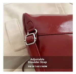 Close-up of adjustable strap with silver metal buckle on red glossy leather backpack