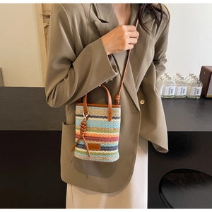 Detail of handmade woven mini tote with rainbow stripes and leather logo patch