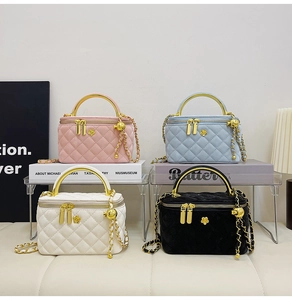 Detailed view of quilted velvet vanity bags in pink, blue, white, and black with gold handles