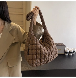 Detailed view of brown quilted cloud bag showing the puffy nylon texture and hobo style