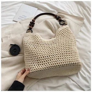 Détail du sac cabas crème tissé à la main avec texture et poignées en bois foncé