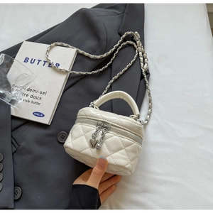 Detail of white quilted mini round box bag with silver heart zipper and chain strap