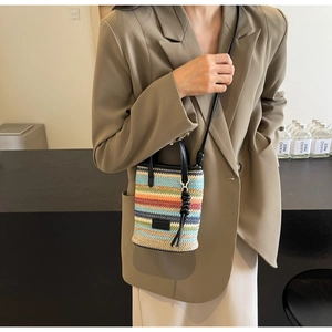 Rainbow striped woven mini crossbody bag with leather straps on a stylish khaki outfit