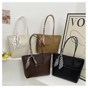 Detail of four textured leather tote bags in white, camel, brown and black with silk scarves