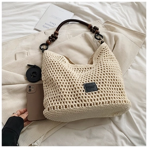 Détail du sac cabas au crochet avec poignée en perles de bois et logo de marque