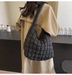 Chic black quilted puff cloud bag worn by a model in a casual lifestyle setting