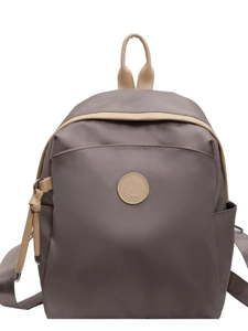 Minimalist dark grey nylon backpack with beige leather trim and contrast straps