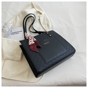 Detail of black checkered tote bag with leopard scarf and front leather pocket