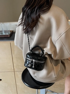 Black quilted mini bucket bag with silver chain strap and heart charm zipper