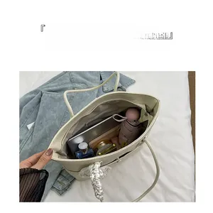 Macro detail of the spacious beige tote bag interior featuring functional compartments