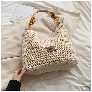 Détail du sac hobo tissé à la main avec anneau décoratif en bois et accents de perles