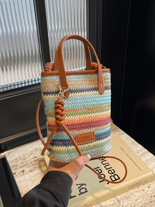 Handheld Bohemian rainbow striped straw bucket bag with brown leather trim and shoulder strap