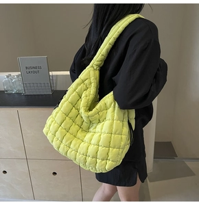 Detail of a large fluorescent yellow quilted tote bag shown from a side-back angle