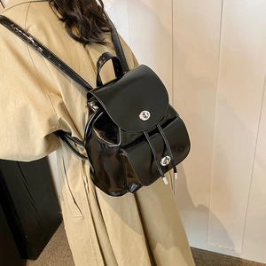 Side view of black glossy patent leather backpack with silver twist-lock fasteners