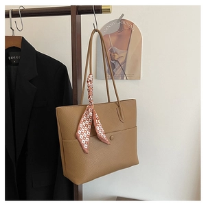 Detail of tan lychee grain tote bag with heart-patterned silk scarf on handle