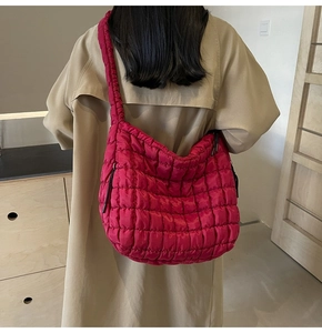 Model wearing a large hot pink quilted bubble hobo bag with a stylish beige trench coat