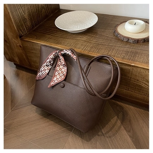Detail of dark brown lychee grain tote bag with decorative heart pattern scarf and front pocket