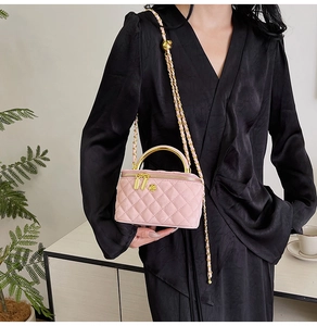 Pink quilted suede mini bag with gold metal handle and chain strap on a model