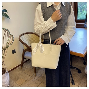 Detail of off-white lychee grain leather tote bag with elegant floral scarf handle wrap