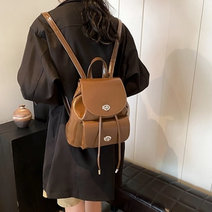 Detail view of vintage brown patent leather mini backpack with silver metallic twist locks