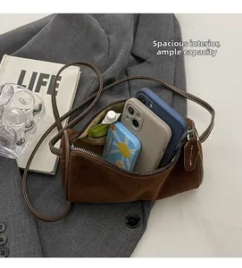 Macro shot showing large storage capacity of a brown suede cylinder crossbody bag