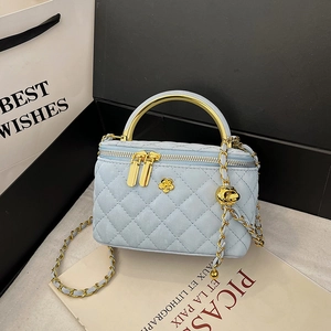 Light blue quilted chain bag with golden camellia floral detail and top handle