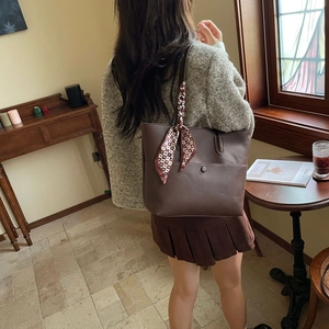 Deep brown pebble leather tote bag featuring a decorative scarf on the handle