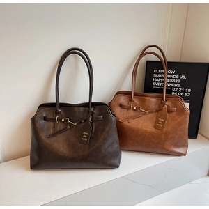 Close-up of matte leather texture and golden buckle detail on retro tote bags