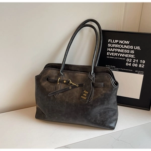 Close-up of retro black tote bag with vintage texture and elegant metal buckle detail
