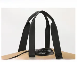 Detail of reinforced padded handle on khaki travel bag with durable black nylon webbing strap