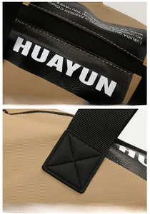 Detail of reinforced X-shaped stitching and white logo print on khaki fitness travel bag