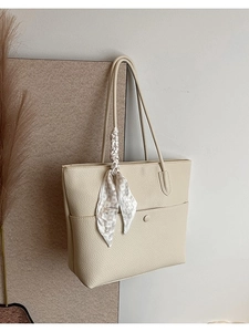 Chic beige lychee leather tote bag with silk scarf accessory and front snap pocket