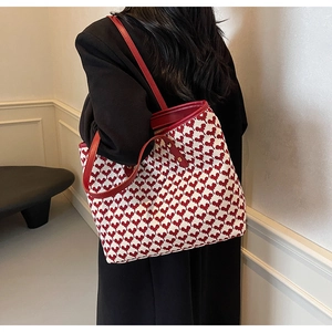 Close-up of red and white heart-patterned knit tote bag with premium leather handles