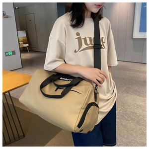 Beige fitness bag detail showing durable nylon material and adjustable black shoulder strap