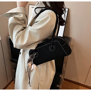 Detail of black rectangular shoulder bag with white contrast stitching and sports charms