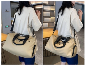 Detail view of beige fitness travel bag featuring sturdy black handles and adjustable strap