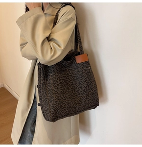Detalle del bolso tote de lona con estampado de leopardo y parche de cuero marrón con remaches