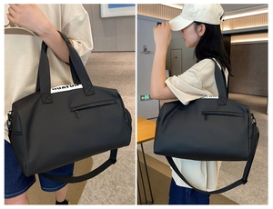 Detail of black gym bag with large capacity, showing side shoulder strap and branding