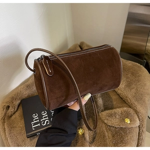 Close-up of a dark brown suede Boston bag featuring silver zipper and matte finish