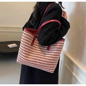 Detail shot of the red and white houndstooth tweed tote bag on a model's shoulder