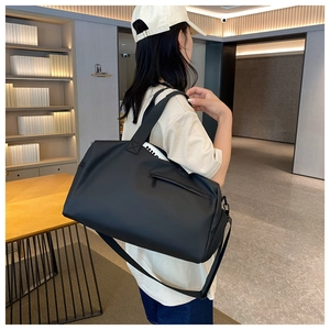 Detailed view of black fitness travel bag shown with adjustable shoulder strap and side pocket