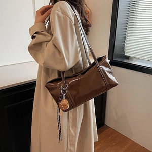Minimalist brown shiny leather underarm bag with thin straps and cute bread charm