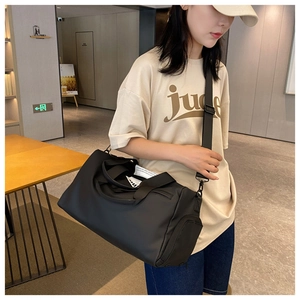 Detail of black sports bag showing wide shoulder strap and durable side zipper pocket