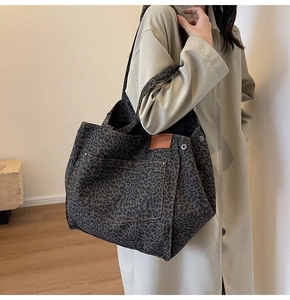 Detalle del bolso tote grande de leopardo con remaches metálicos y lona