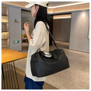 Modern black sports travel bag with adjustable strap and side zipper pocket detail