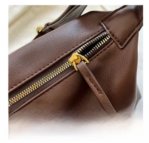 Détail de la fermeture éclair dorée sur le sac cabas en cuir marron texturé souple