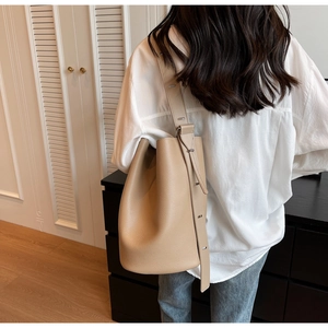 Detail of the litchi-textured leather bucket bag with wide adjustable shoulder strap
