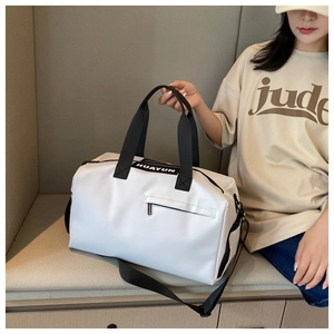 Detail view of large white gym bag with durable shoulder straps and functional zip pockets