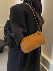 Women's chic caramel brown suede Boston shoulder bag worn with a black blazer